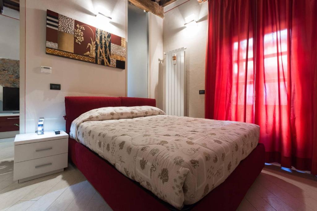 都灵Perla al centro di Torino - next Mole的一间卧室配有一张带红色窗帘的大床