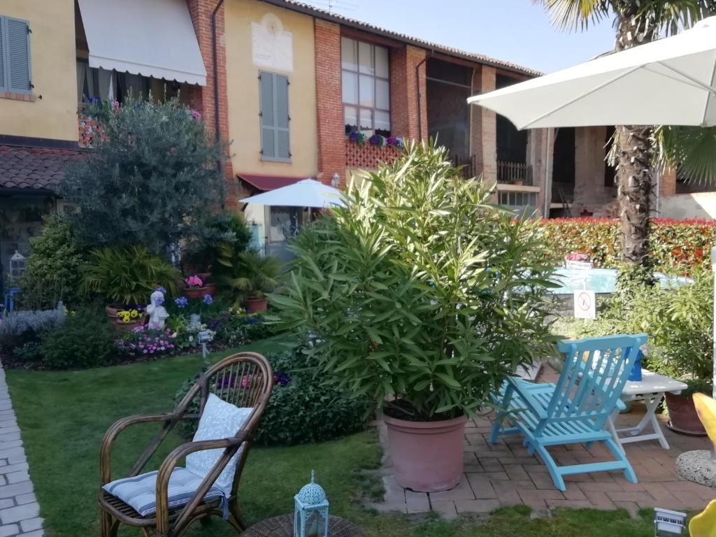 Occimiano圣瓦勒里奥住宿加早餐旅馆的一个带椅子和植物的庭院和一把伞