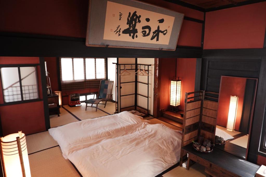 广岛一棟貸ゲストハウス 傾㐂屋 Kabukiya的一间有标志的房间,卧室配有一张床