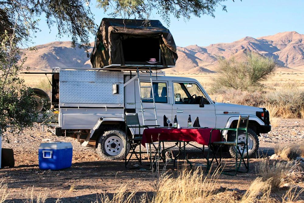 索利泰尔Namib Desert Campsite的一辆白色卡车,上面有帐篷
