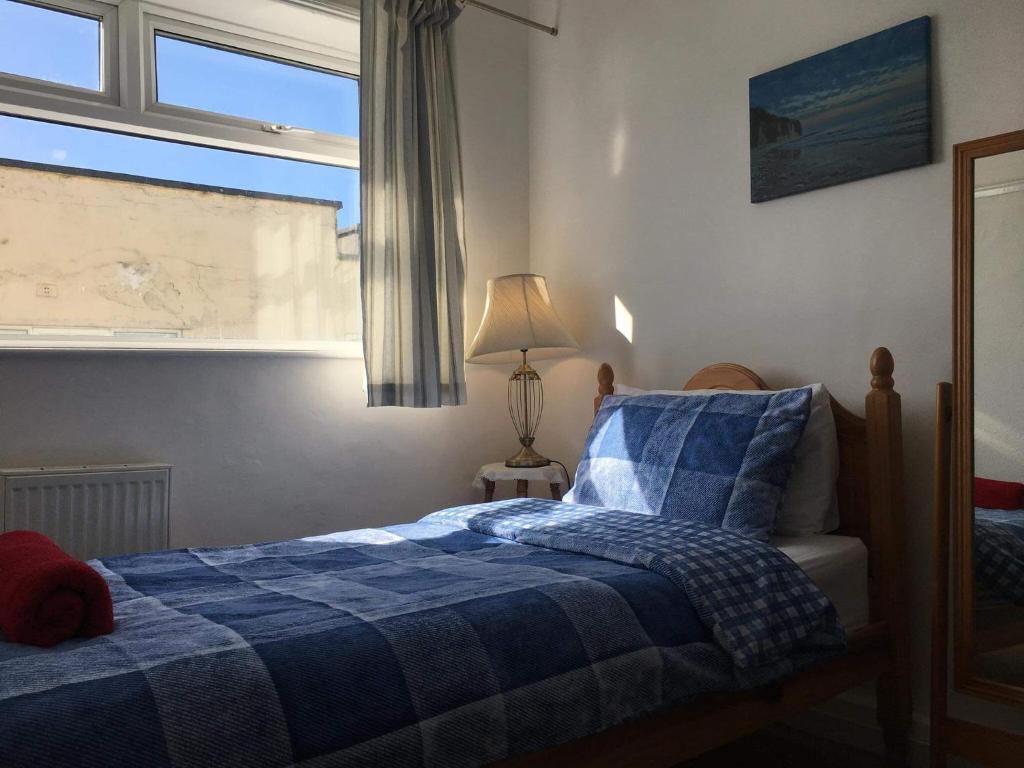 布里德灵顿Clifftop Apartment的一间卧室设有蓝色的床和窗户。