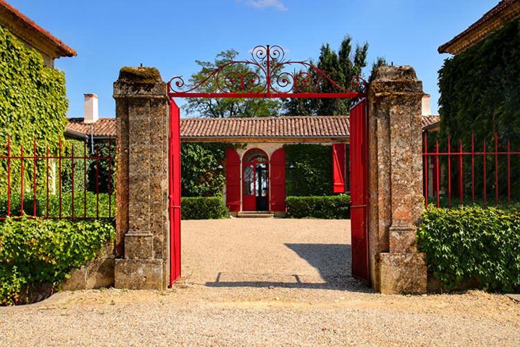BommesChâteau Sigalas Rabaud的房屋前的红色门