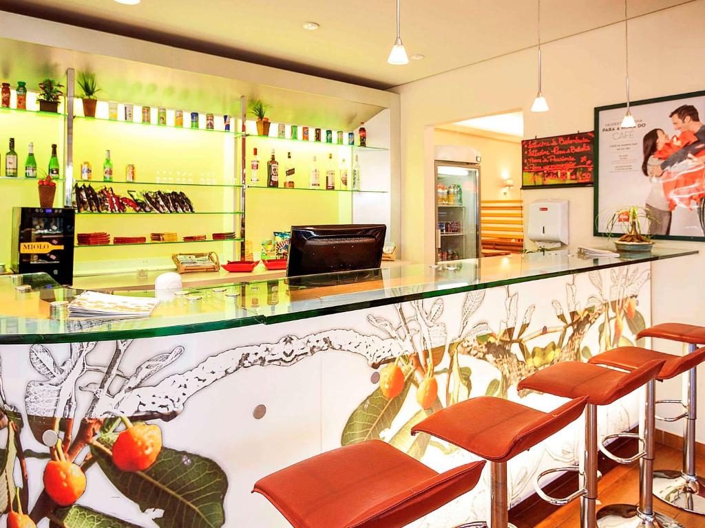 乌贝兰迪亚ibis Uberlandia的餐厅设有酒吧,配有棕色皮革凳