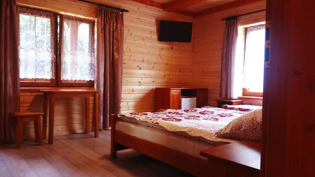 扎沃亚Willa Wiktoria的卧室配有一张床、一张书桌和窗户。