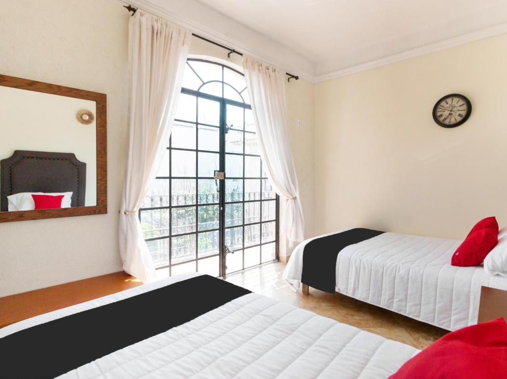 圣路易斯波托西Capital O San Jose, San Luis Potosi的一间卧室设有两张床和大窗户