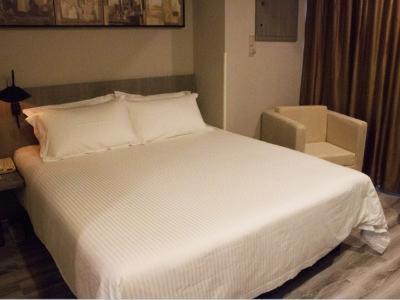 杭州JinJiang Inn Hangzhou Road subway station Xiasha High Fashion Hotel的卧室配有一张白色床和小刀