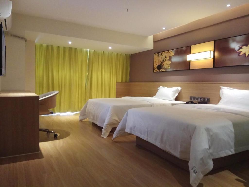 贵阳IU酒店·贵阳金阳世纪城购物中心茶园村地铁万科店的酒店客房设有两张床和电视。