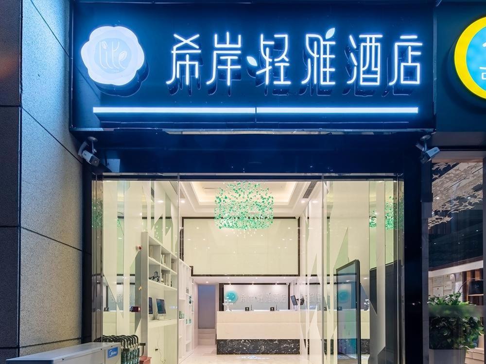 贵阳希岸·轻雅酒店贵阳国际会展中心金融城店的窗口上方带有蓝色标志的商店前方