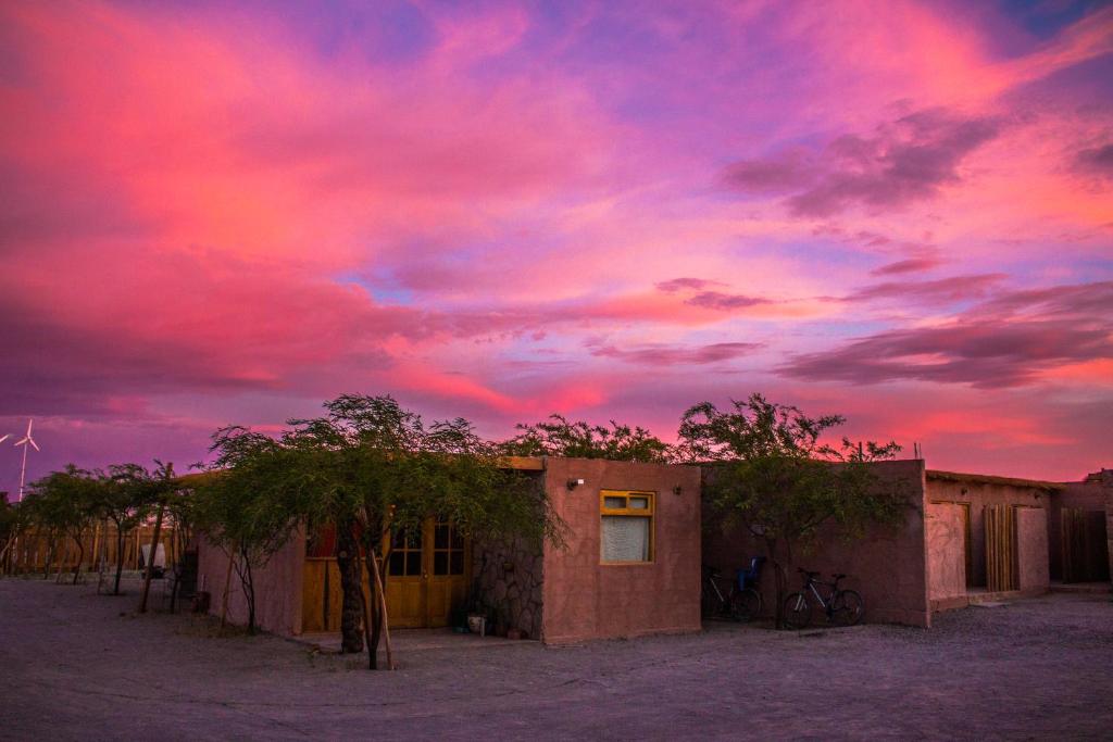 ChíuchíuSol del Desierto的沙漠中一座建筑的日落