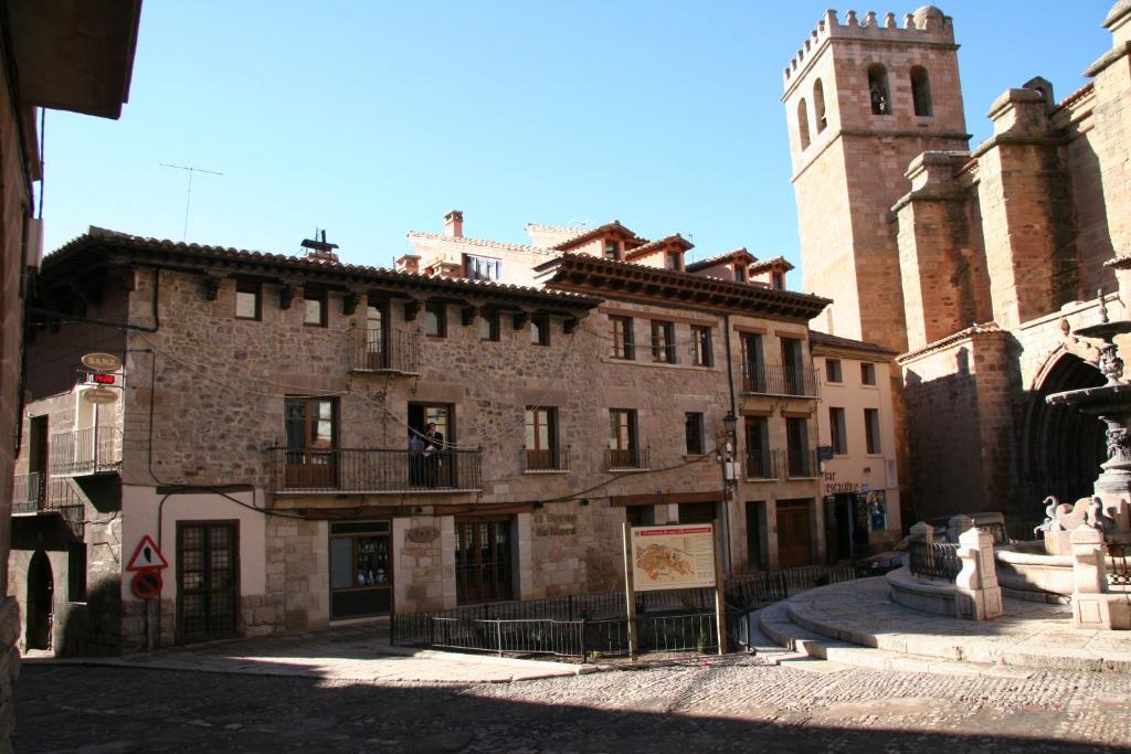 摩拉鲁比罗Apartamentos La Iglesia的街道上一座古老的石头建筑,有钟楼