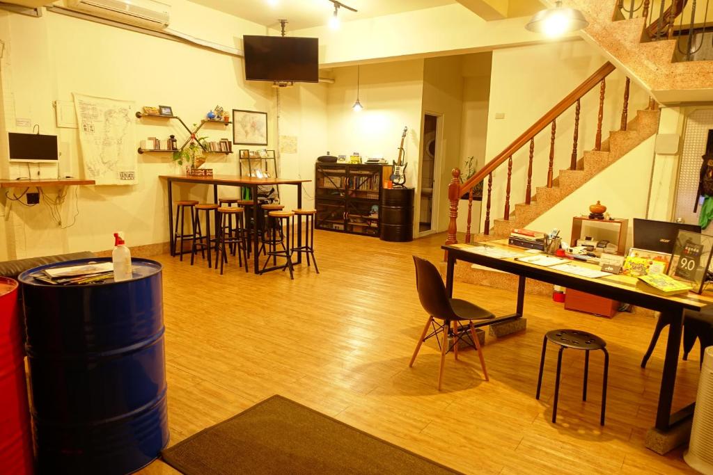 嘉义市Chiayi Petite Hostel的一间带桌椅和楼梯的客厅