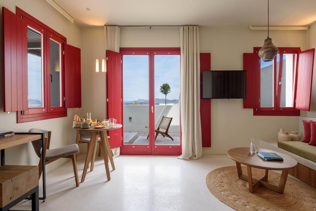 阿克罗蒂里Potnia Theron Suites的一间客厅,配有红色橱柜和红色门