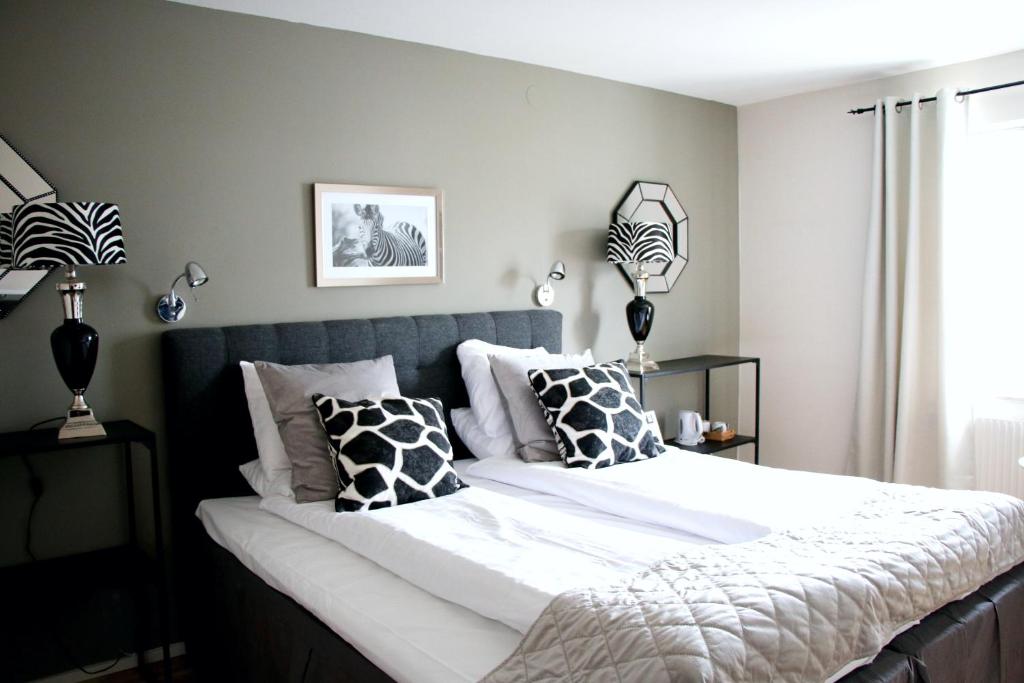 卡尔斯港Hotel Carlshamn的一间卧室配有一张大床,提供黑白枕头