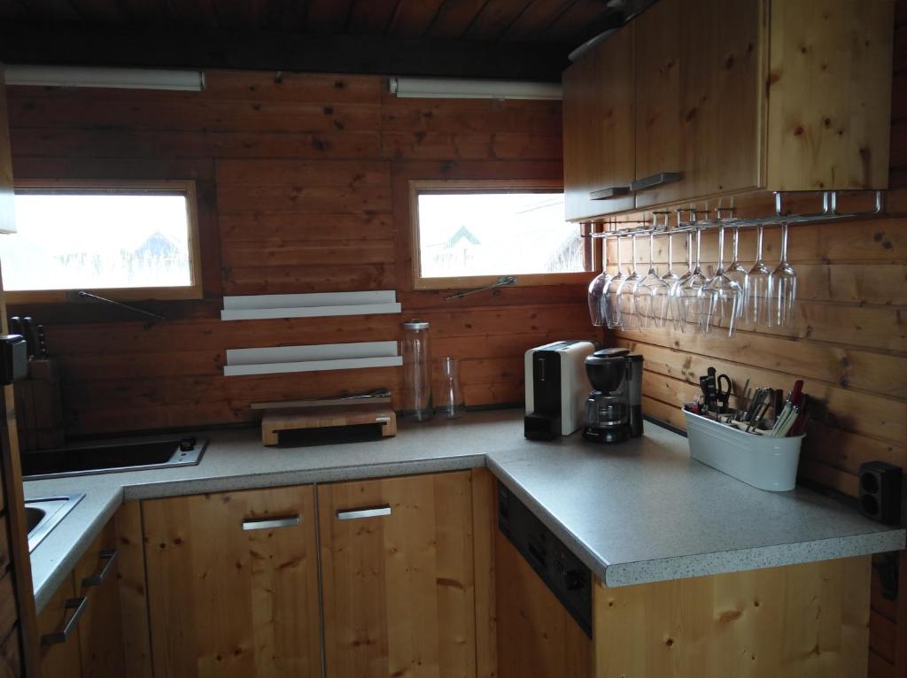 拉斯特Pfahlbau Rust/Neusiedlersee Sunset II的厨房配有木制橱柜和带玻璃杯的台面