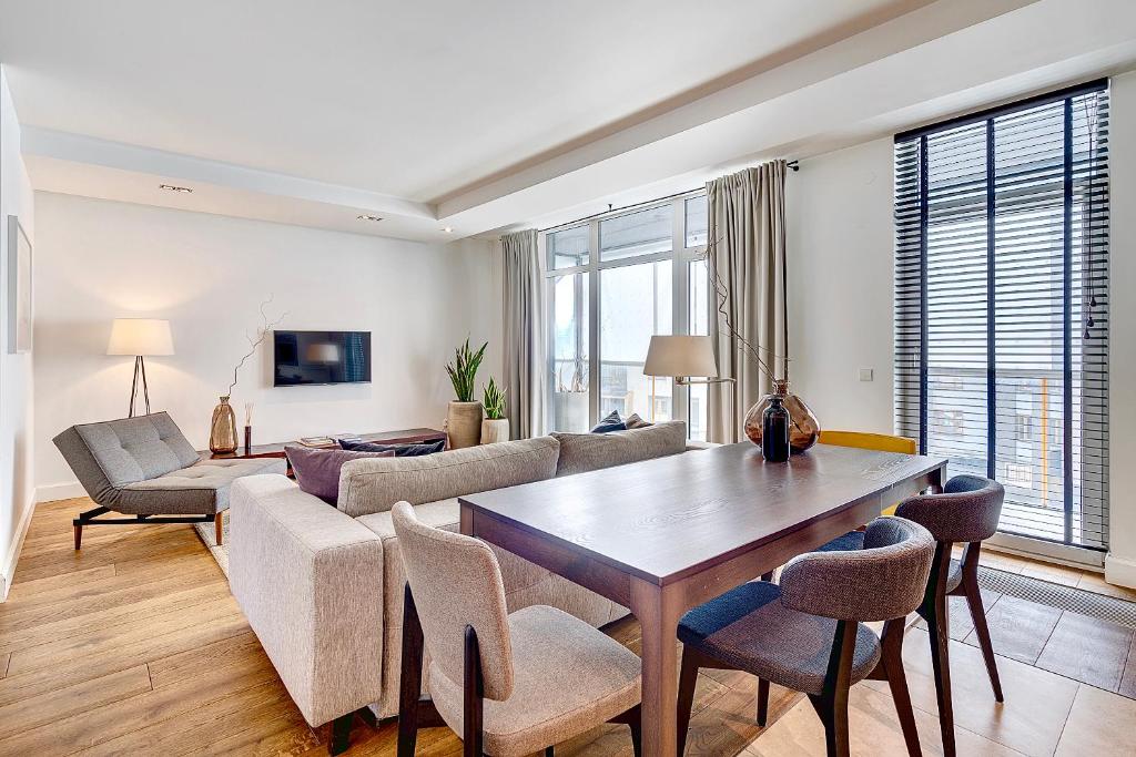 维尔纽斯维尔纽斯公寓和套房的客厅配有沙发和桌椅