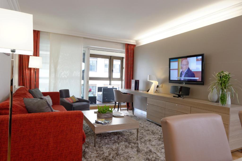 巴黎阿尔玛玛索酒店的客厅配有红色沙发和电视