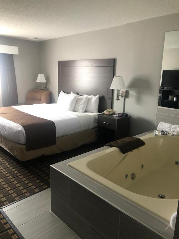 AdamsAdams Inn and Suites的酒店客房配有一张床和浴缸。