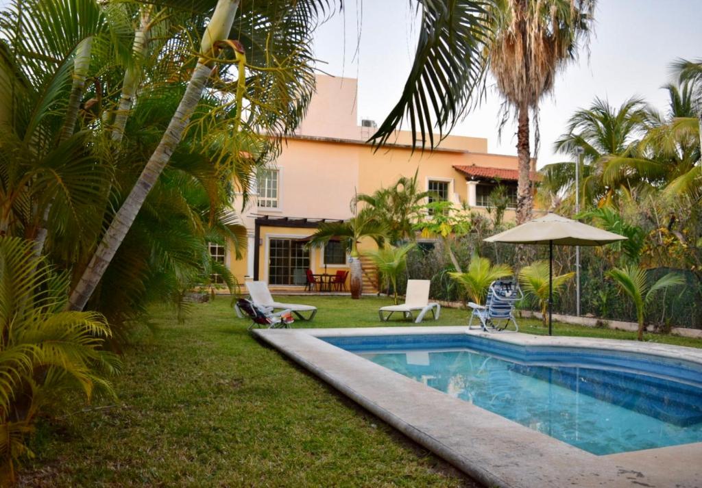 坎昆Cancun-Soho的棕榈树屋前的游泳池