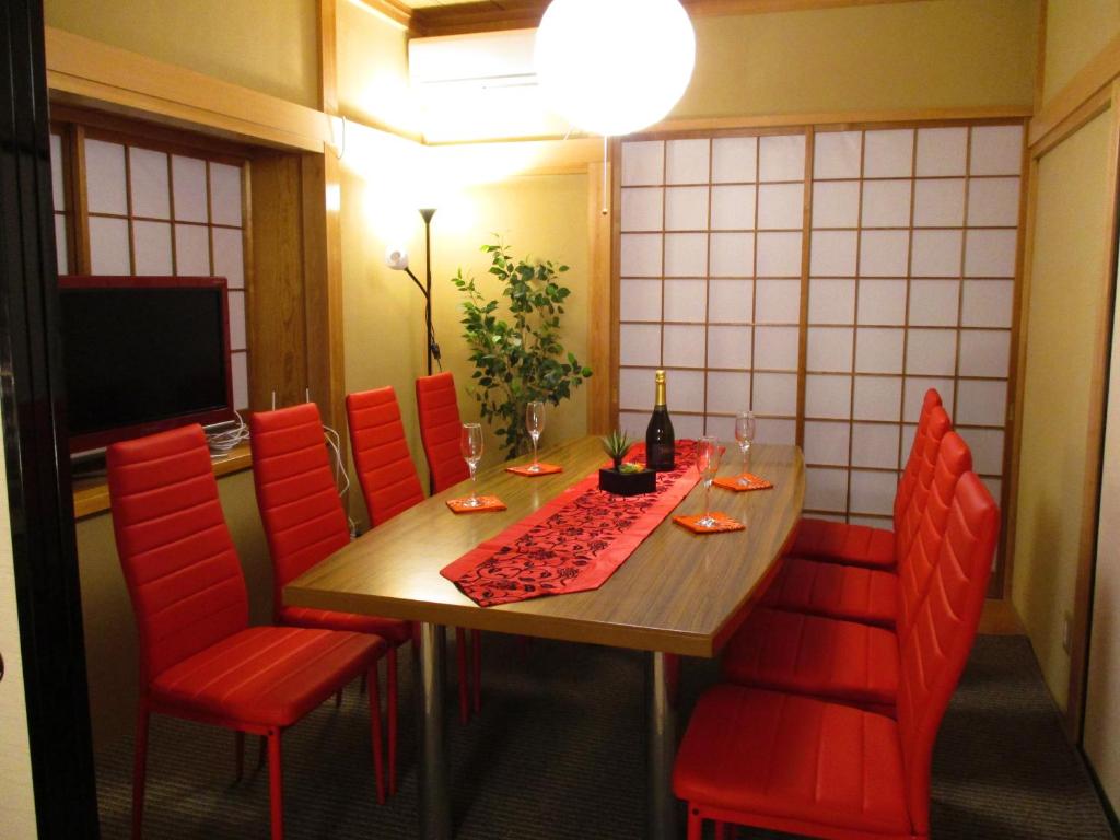 富士吉田市Tsukitei1的一间带桌子和红色椅子的用餐室
