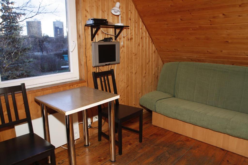 维尔纽斯乔利曼农家乐的客厅配有沙发和桌子