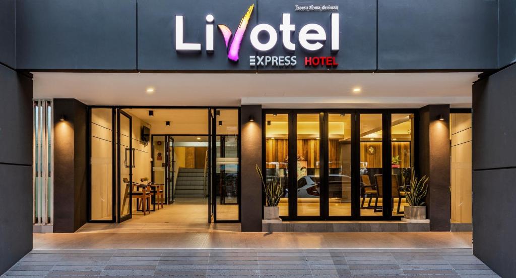 曼谷Livotel Express Hotel Ramkhamhaeng 50 Bangkok的一间豪华公寓大楼前的商店,设有旋转门