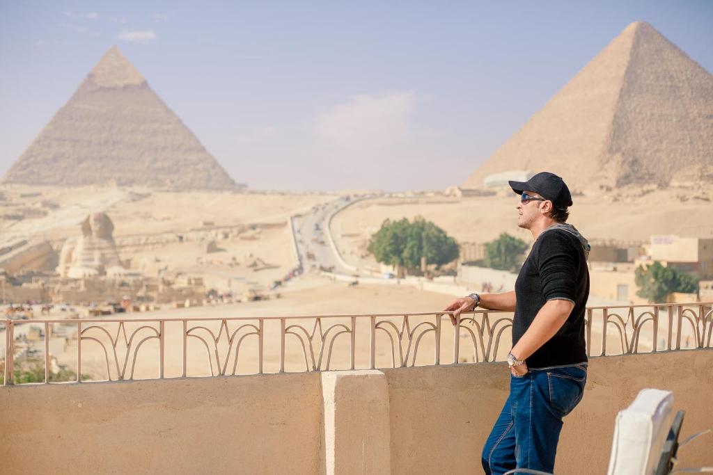开罗卫报旅馆的站在墙上看金字塔的人