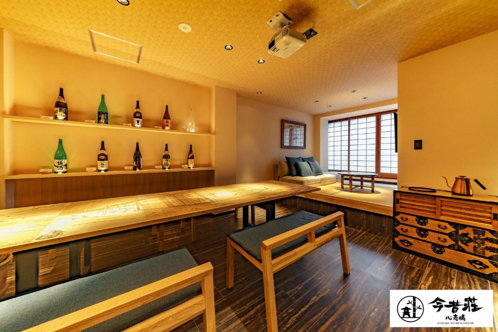 大阪Konjaku-So Shinsaibashi Rooftop SPA的一间房间,墙上装有瓶子的酒吧