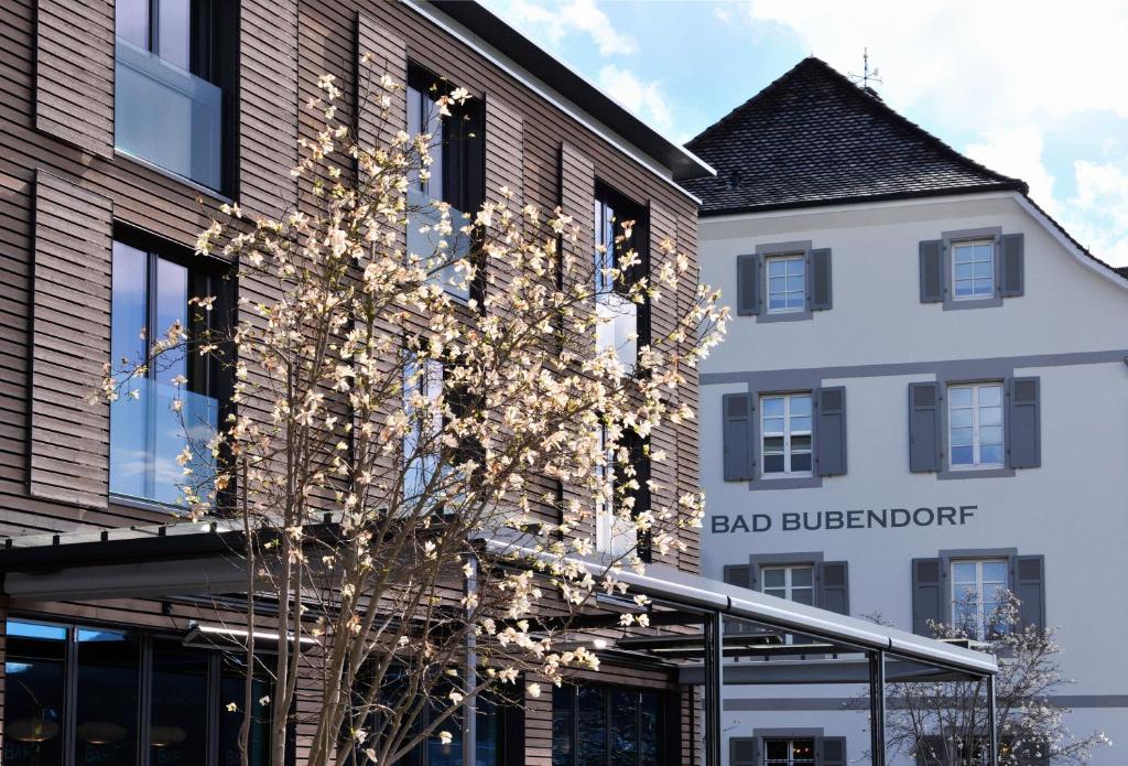 BubendorfBad Bubendorf Design & Lifestyle Hotel的前面有棵树的建筑