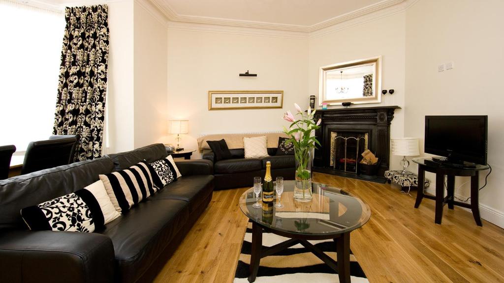 都柏林都柏林短期租赁公寓的客厅配有黑色沙发和壁炉