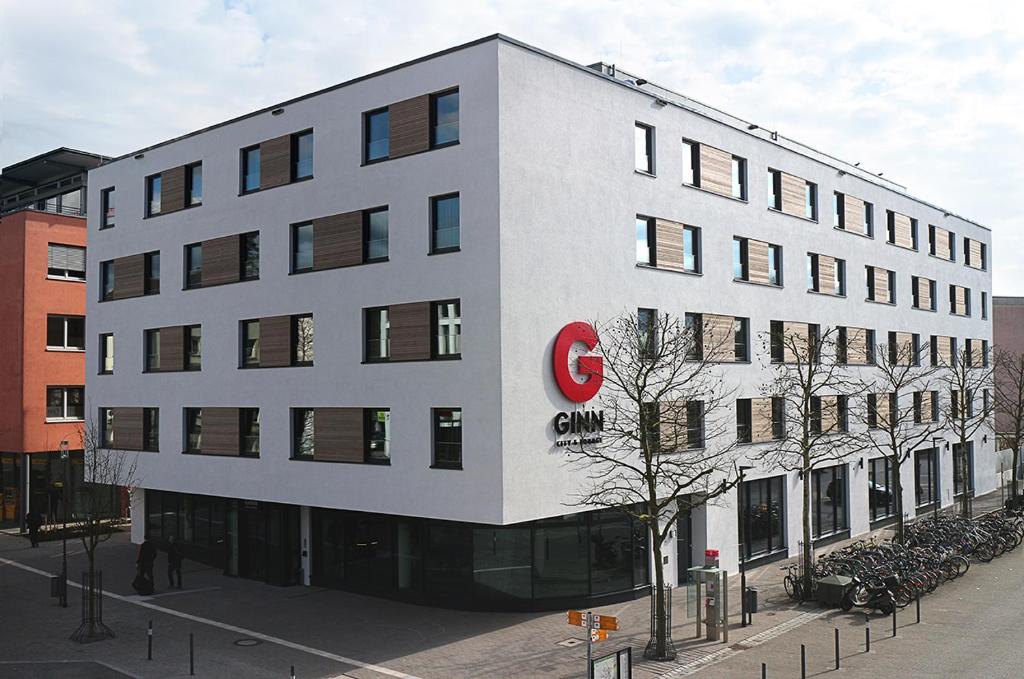 拉芬斯堡GINN City and Lounge Ravensburg的一座白色的大建筑,上面有红色的c