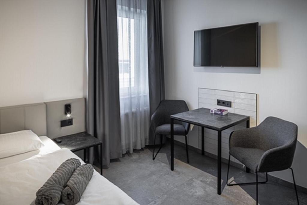 普尔海姆Home & Work的酒店客房设有床、桌子和电视。