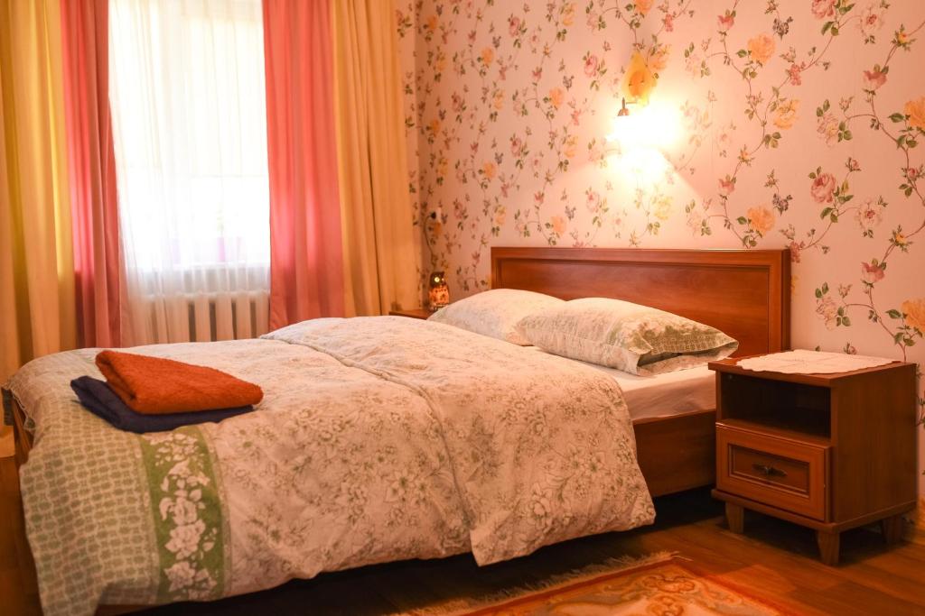 ShostkaApartment Horkoho 7A的一间卧室配有床、床头柜和窗户