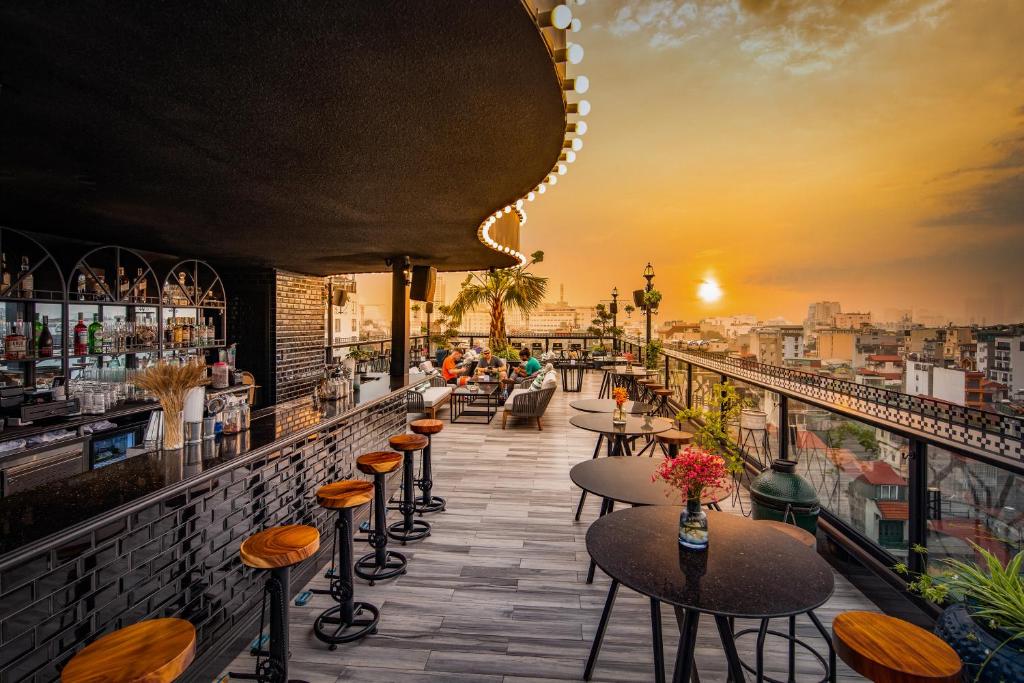 河内Solaria Hanoi Hotel的日落时分享有城市美景的酒吧