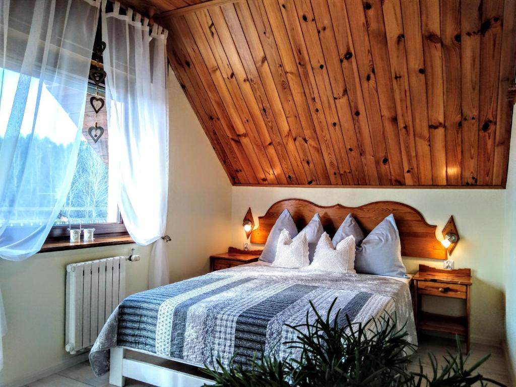 波别罗沃Jarek的一间卧室设有一张木天花板床。