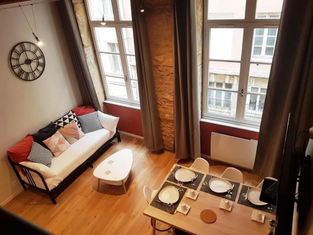 里昂Cosy appartement, dans les pentes de la Croix Rousse的客厅配有沙发和桌子