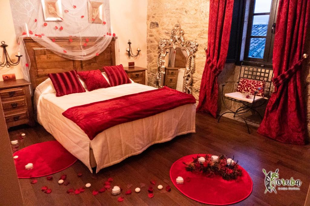 AmésCasa Rural Yoruba的一间卧室配有一张带红色枕头和红色装饰的床。