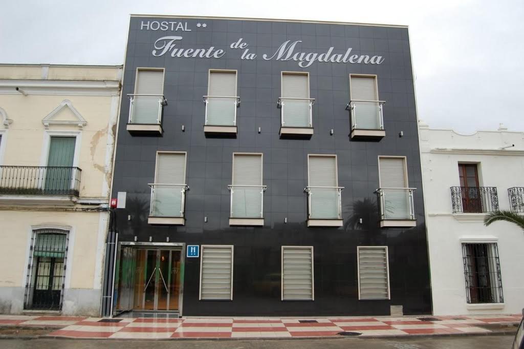 Santa Amalia马格达莱纳富恩特酒店的一座黑色的建筑,旁边有一个标志
