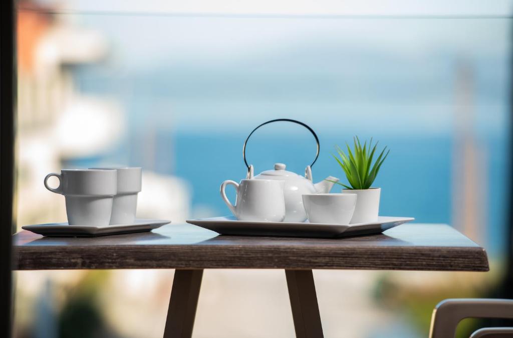 萨尔蒂Sarti Premium Suites的茶杯和盘子的桌子