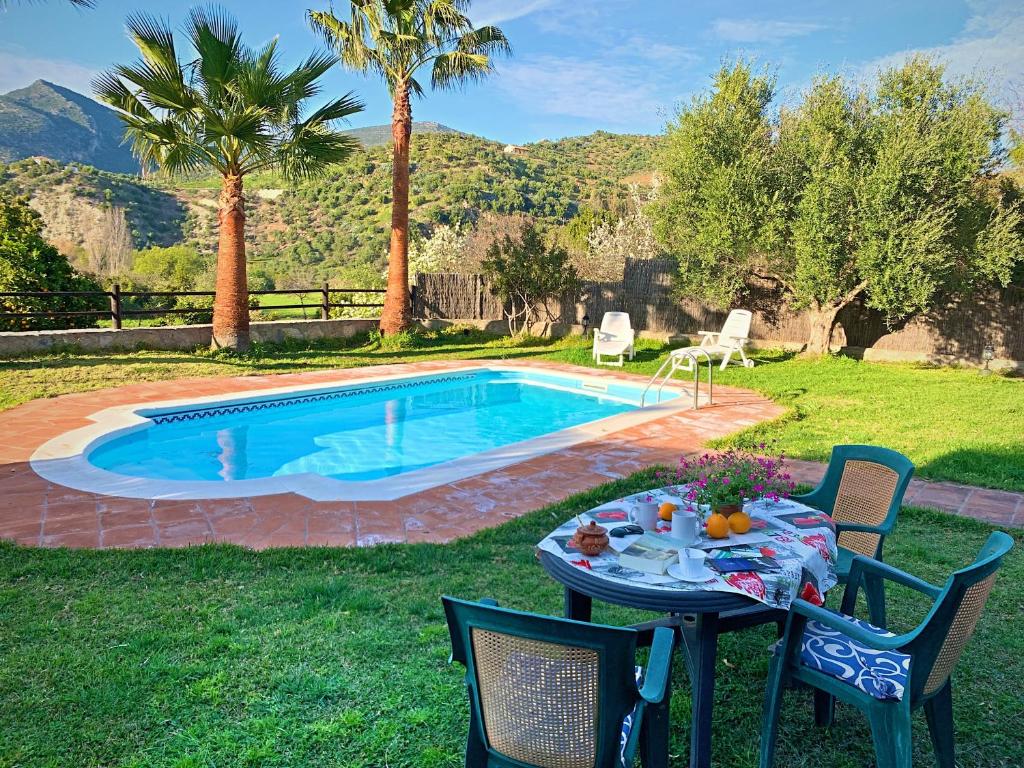 扎哈拉Acogedora casa rural en Zahara de la Sierra的游泳池旁的桌椅