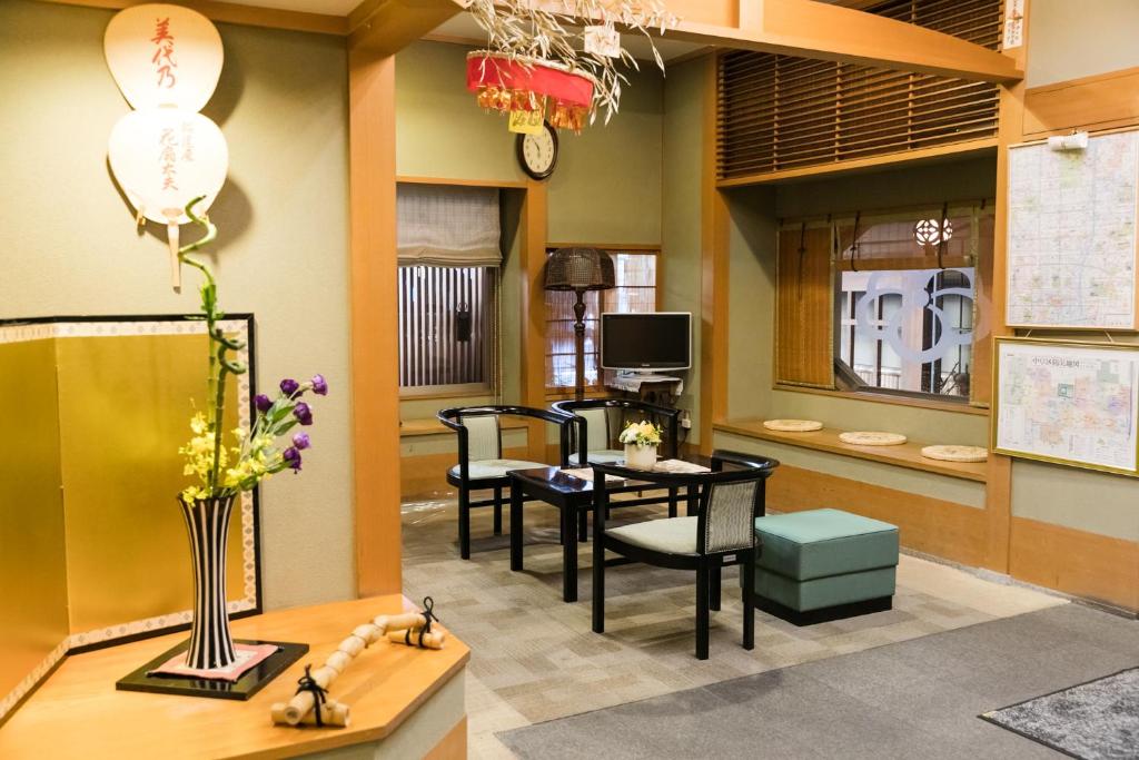 京都京之宿家平酒店的客厅配有桌椅和电视。