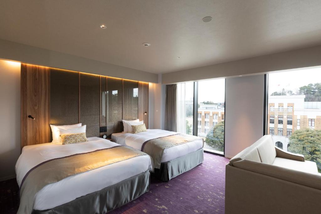 金泽First Hotel Kanazawa的酒店客房,设有两张床和一张沙发