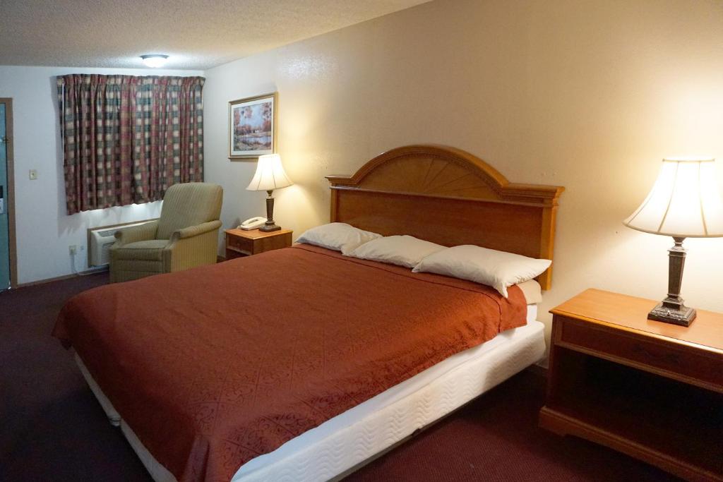 阿尔特斯OYO Hotel Altus N Main St的配有一张床和一把椅子的酒店客房