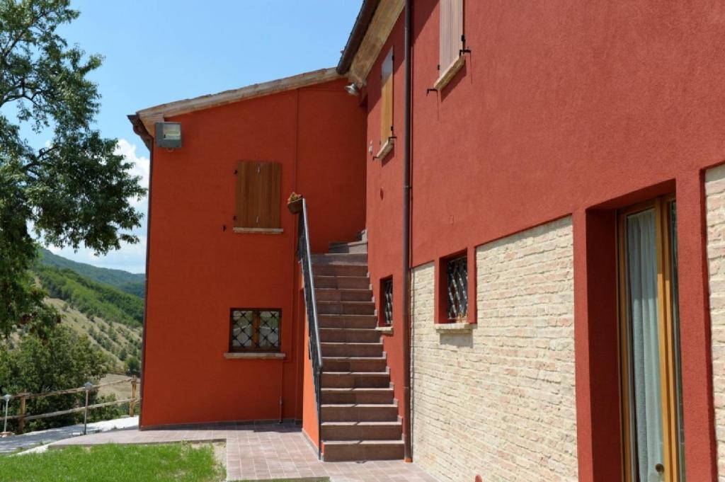 乌尔巴尼亚Guest house Agriturismo i Conti CIR 16277的一座红色的建筑,旁边设有楼梯