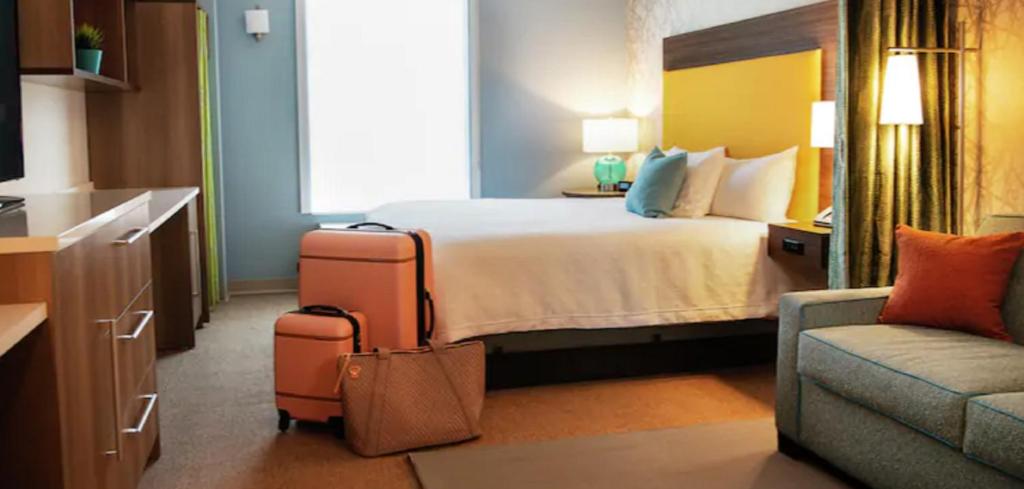 埃尔克哈特Home2 Suites By Hilton Elkhart的酒店客房,配有床、沙发和行李