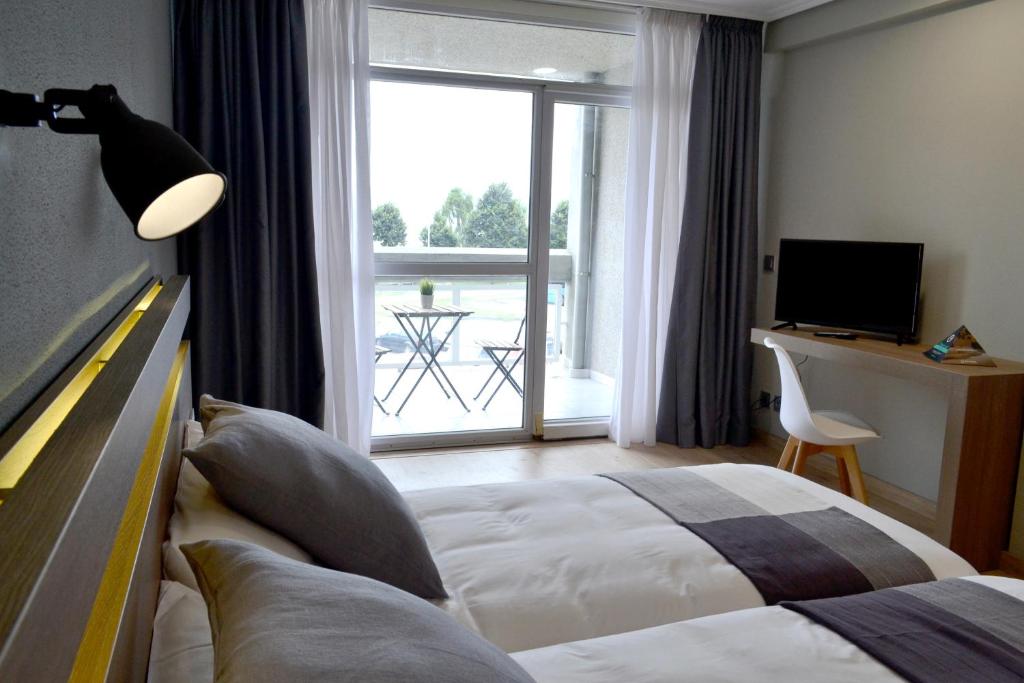 萨达Hotel Alda Sada Marina的酒店客房设有一张床和一个大窗户