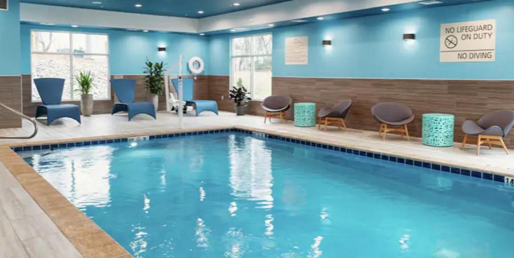 PekinHampton Inn & Suites Pekin (Peoria Area), Il的大堂的游泳池,设有蓝色的墙壁和椅子