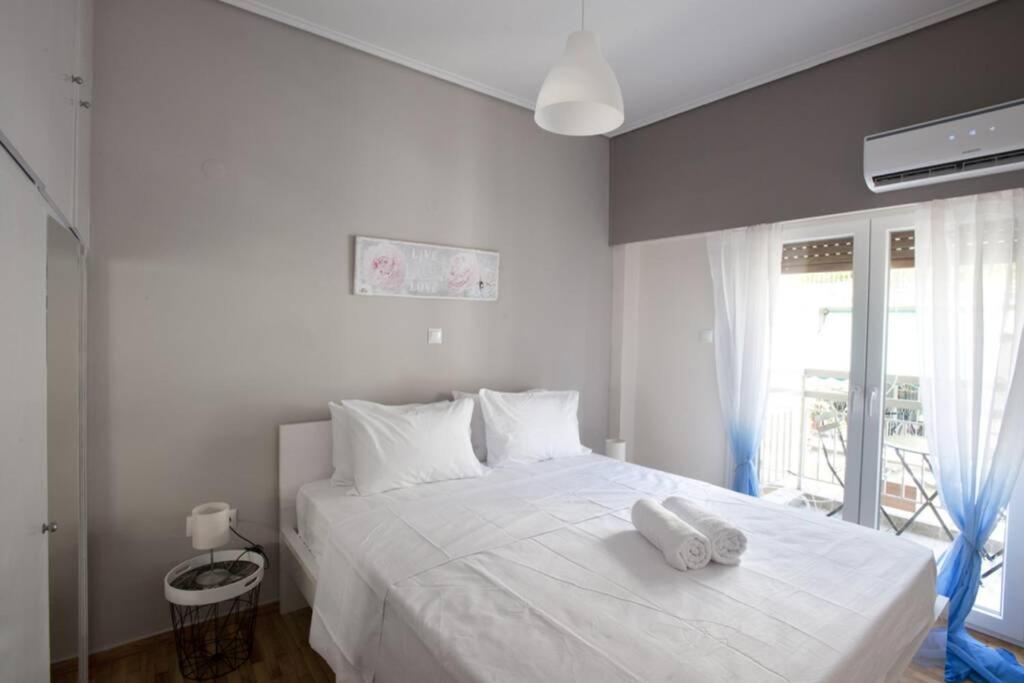 雅典Zan Moreas, A simple & minimal apartment的卧室配有白色床和毛巾