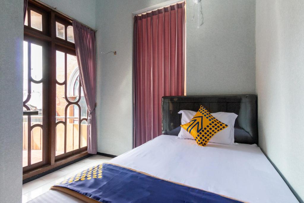 拉旺SPOT ON 2689 Safira Family Residence Syariah的一间卧室设有一张床和一个大窗户