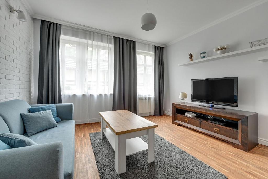 索波特Willa Morska Superior by Grand Apartments的客厅配有蓝色的沙发和电视