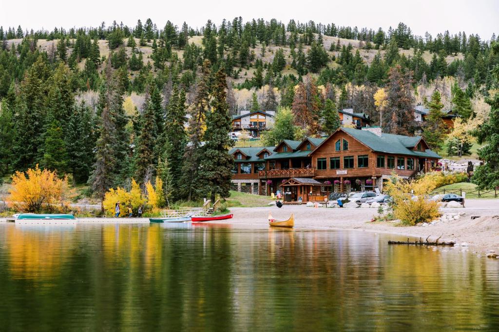 贾斯珀Pyramid Lake Lodge的湖岸上的小屋,水中有船